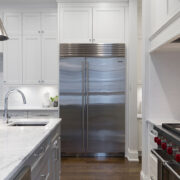 A stainless steel refrigerator in a white home kitchen