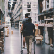 Two people walking down the aisles of a hardware store